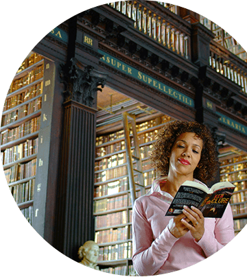 A woman reading a book in front of a bookstore.